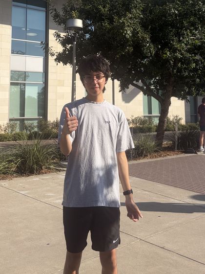 Ethan giving a thumbs up outside a campus building